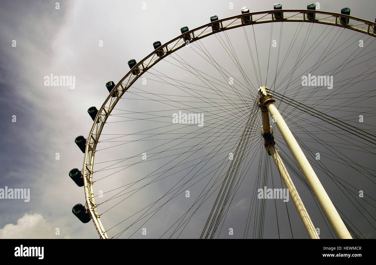 The Singapore Flyer, a giant Ferris wheel located at 30 Raffles Ave, stands at 165 meters tall and opened in 2008. Designed by Kisho Kurokawa, it offers panoramic views of Singapore's skyline. Stock Photo