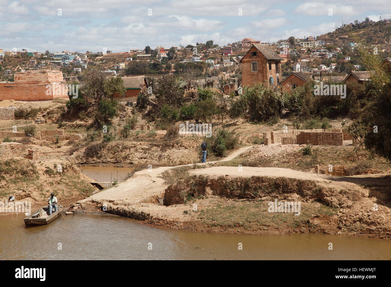 Mud brick houses, man fishing on the outskirts of Antananarivo Stock Photo