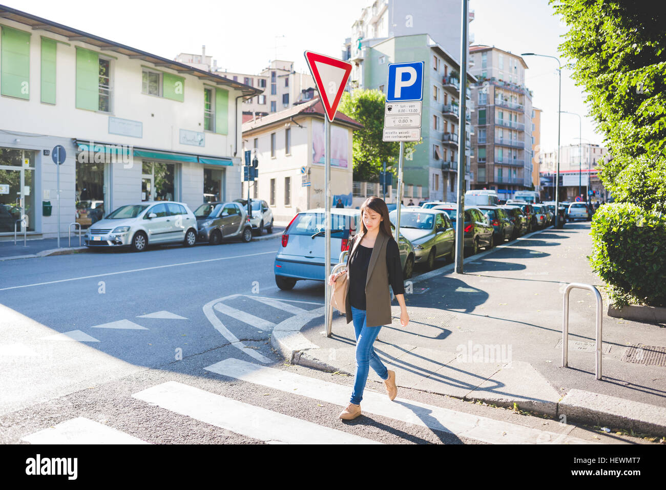 Young woman strolling across city pedestrian crossing Stock Photo - Alamy