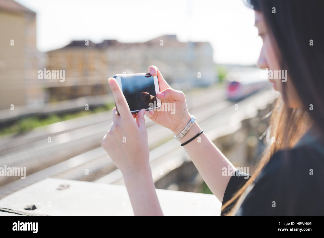 Young woman on city roof terrace looking at smartphone Stock Photo