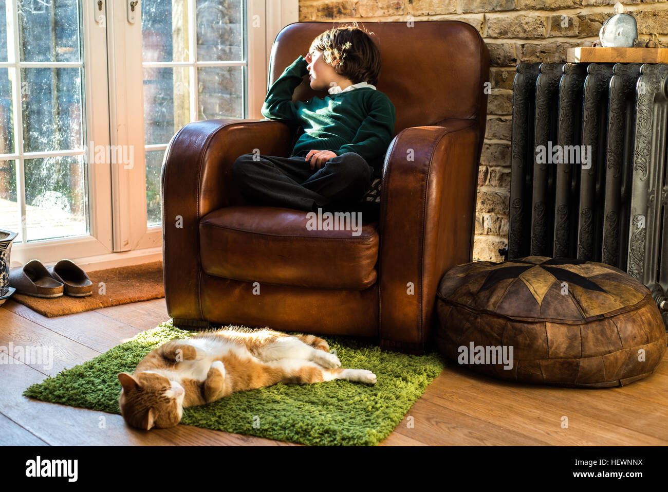 Boy relaxing on arm chair after school Stock Photo