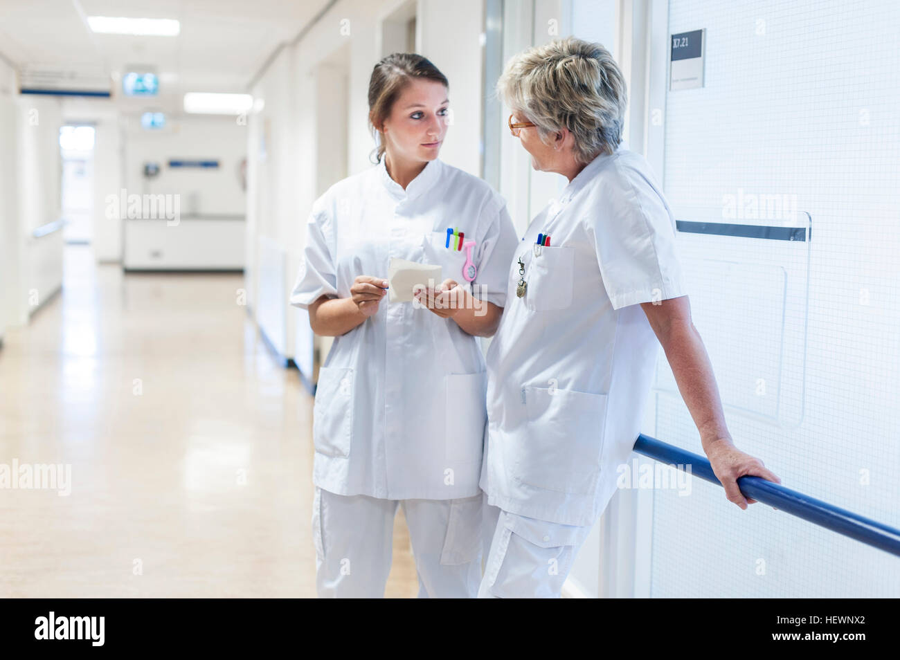 Nurses in hospital corridor having discussion Stock Photo
