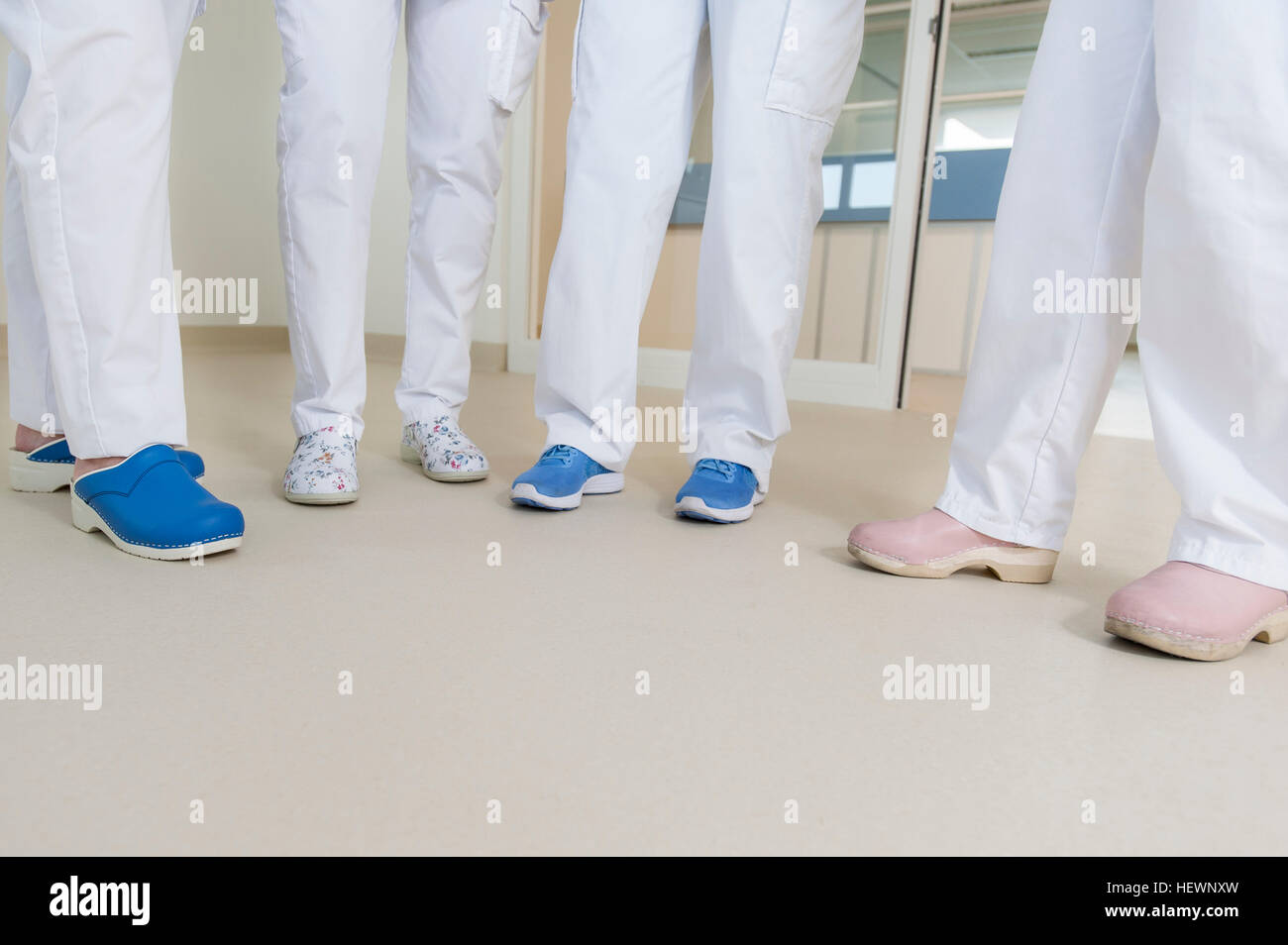 Low section of group of nurses wearing surgical scrubs and clogs Stock Photo