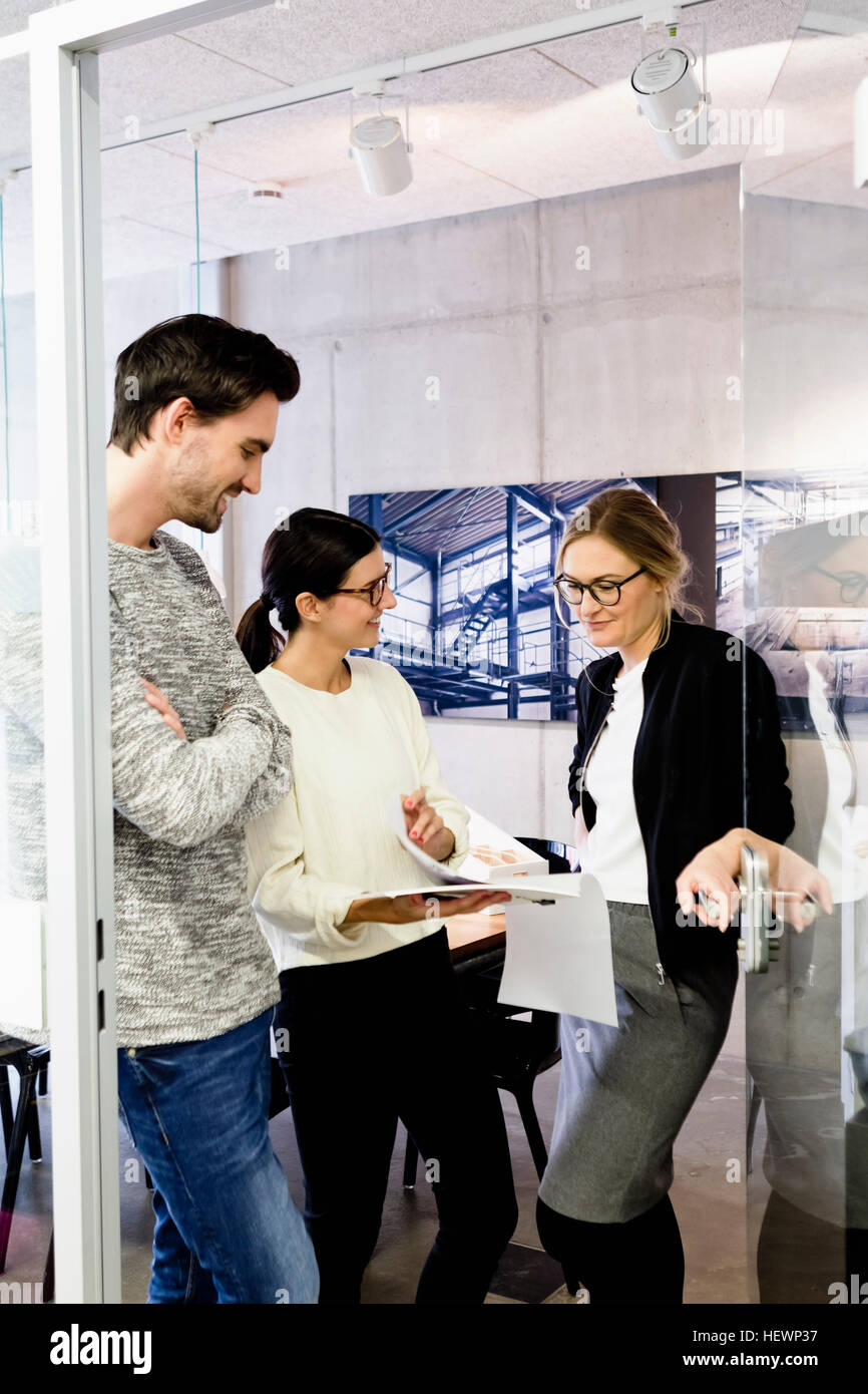 Colleagues in office doorway chatting Stock Photo