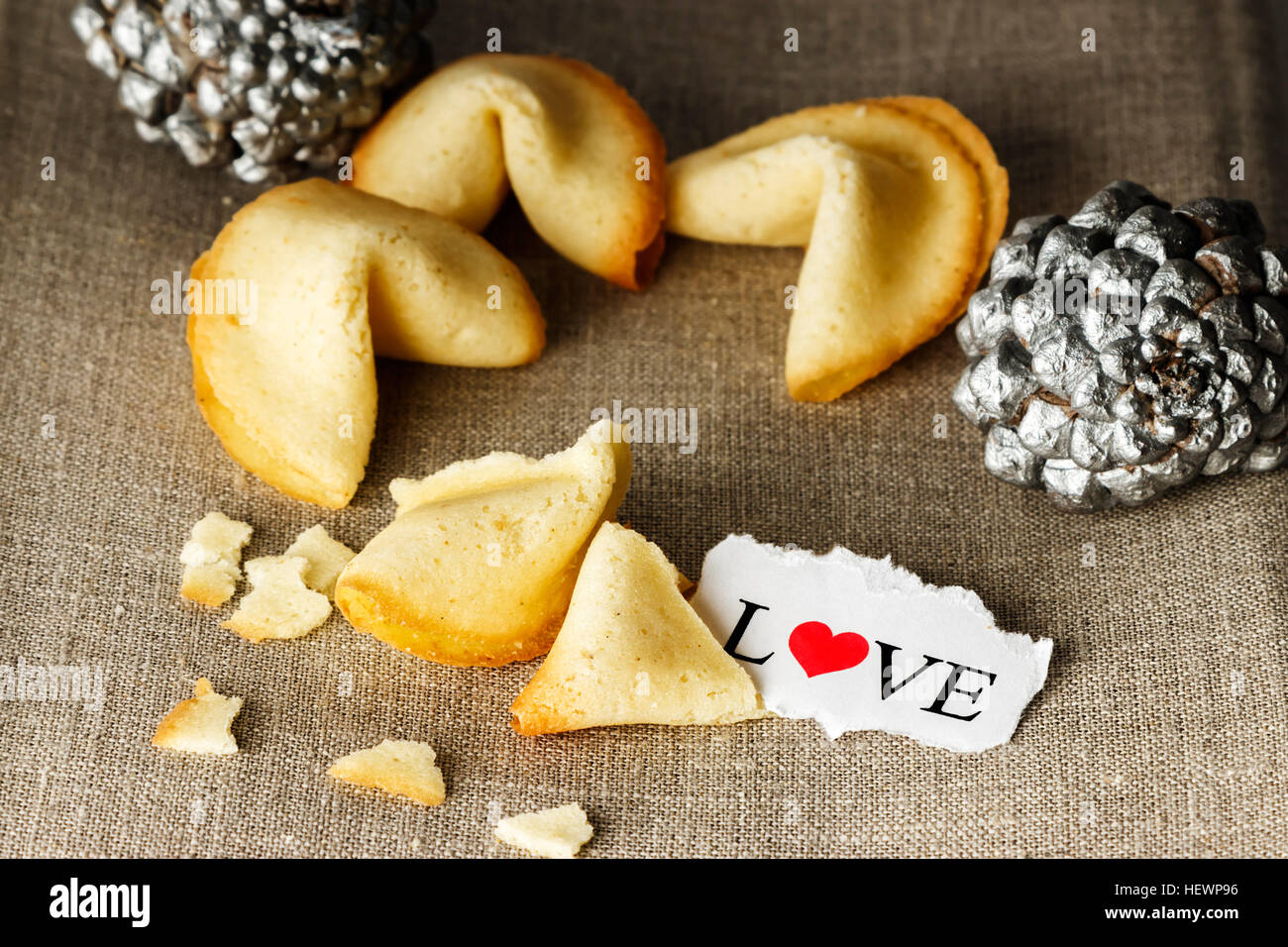 Cookies shaped like tortellini with the word love written on a paper and two silver pineapples in the background.Horizontal image. Stock Photo