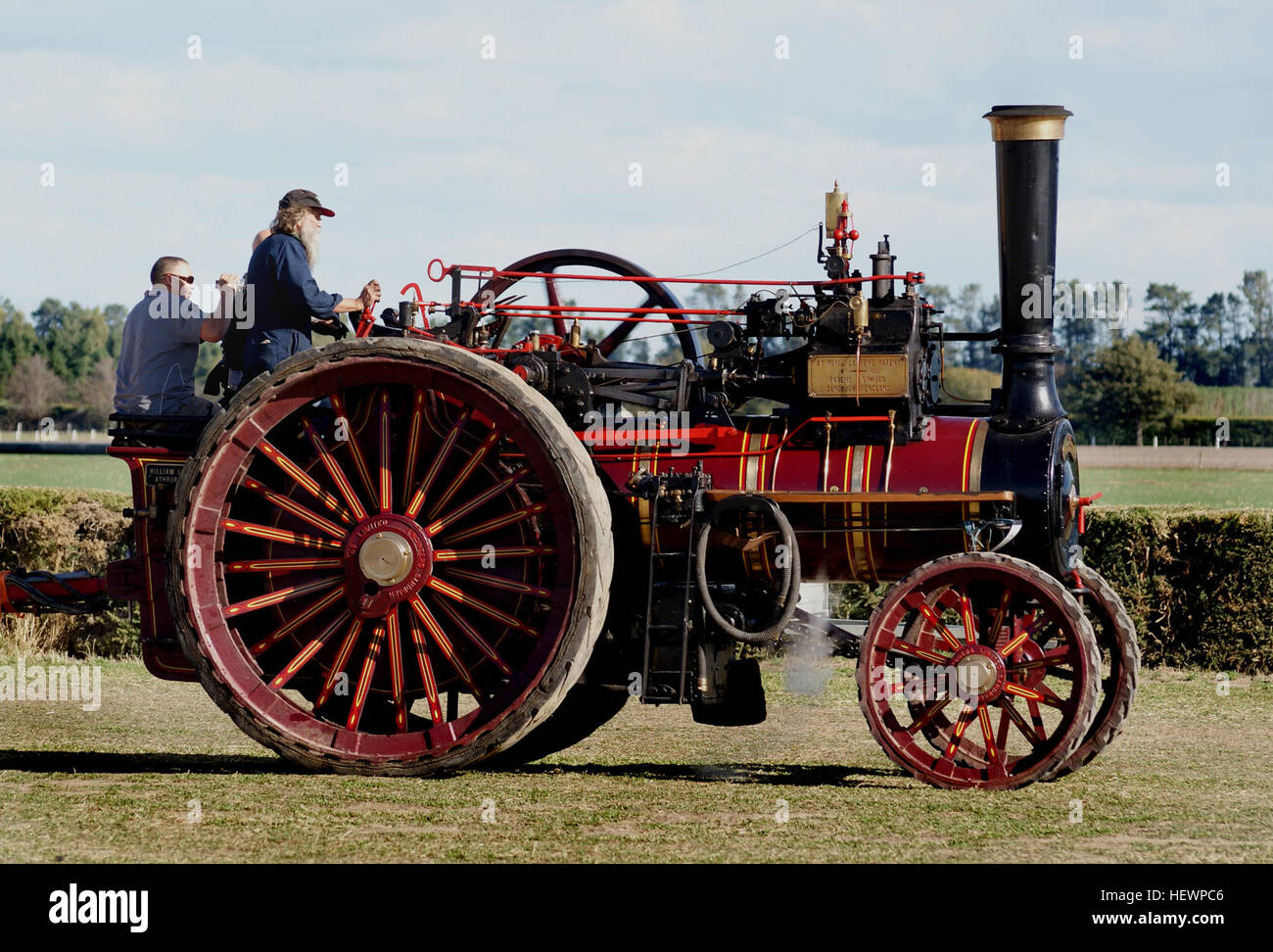A traction engine is a self-propelled steam engine used to move heavy loads on roads, plough ground or to provide power at a chosen location. The name derives from the Latin tractus, meaning 'drawn', since the prime function of any traction engine is to draw a load behind it. They are sometimes called road locomotives to distinguish them from railway locomotives – that is, steam engines that run on rails.  Traction engines tend to be large, robust and powerful, but heavy, slow, and difficult to manoeuvre. Nevertheless, they revolutionized agriculture and road haulage at a time when the only al Stock Photo