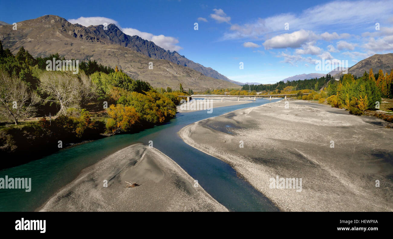 The Shotover River is located in the Otago region of the South Island of New Zealand.The name correctly suggests that this 75-kilometre (47 mi) long river is fast flowing, with numerous rapids. The river flows generally south from the Southern Alps on its journey running through the Skippers Canyon, draining the area between the Richardson Mountains and the Harris Mountains, before flowing into the Kawarau River east of Queenstown .Gold mining featured in its early history and it was one of the richest gold-bearing rivers in the world. Beginning in 1862 when gold was first discovered on the ri Stock Photo