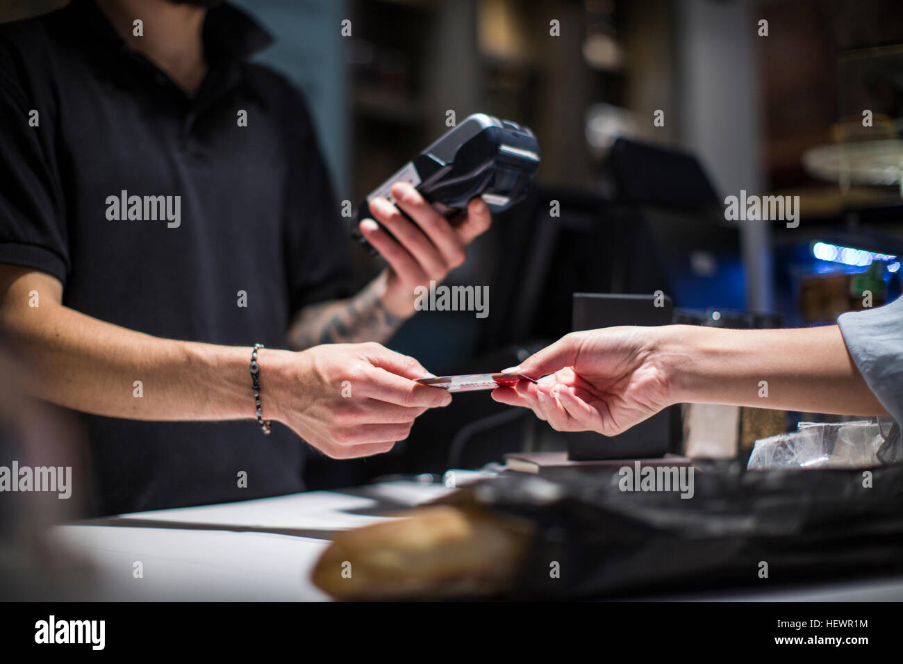 Close up of barista handing credit card to female customer Stock Photo