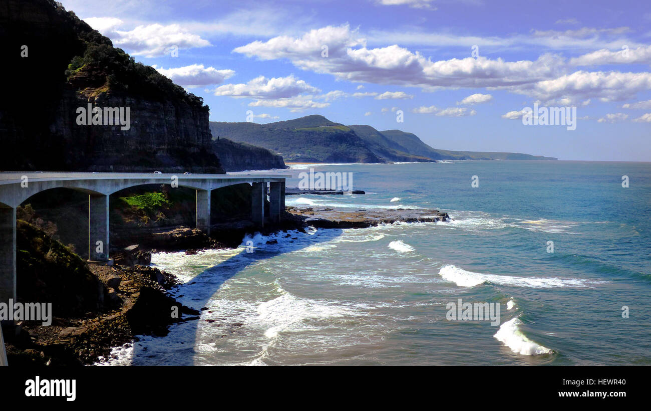 The Sea Cliff Bridge is a balanced cantilever bridge located in the northern Illawarra region of New South Wales, Australia. The $52 million bridge links the coastal villages of Coalcliff and Clifton. Featuring two lanes of traffic, a cycleway and a walkway, the Sea Cliff Bridge boasts spectacular views and is a feature of the scenic Lawrence Hargrave Drive.  The Sea Cliff Bridge replaced a section of Lawrence Hargrave Drive that was permanently closed in August 2003 due to regular rock falls. A public outcry emerged over the road closure as Lawrence Hargrave Drive is the only road directly li Stock Photo