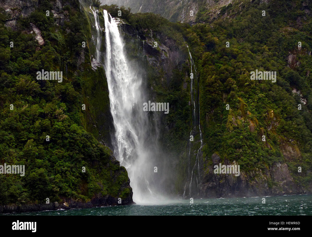 One of the Must See New Zealand Waterfalls, Stirling Falls, second name Waimanu Falls, is the most magnificent waterfall in the world's famous Milford Sound. Accessible via a Milford Sound Cruise or Milford Sound Scenic Flight. Stock Photo