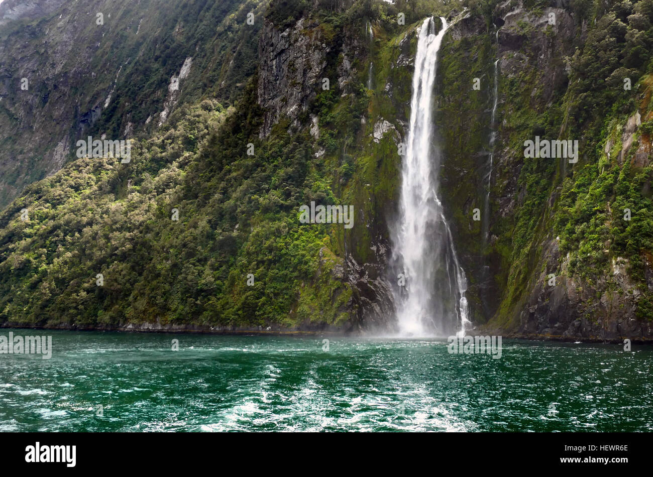 One of the Must See New Zealand Waterfalls, Stirling Falls, second name Waimanu Falls, is the most magnificent waterfall in the world's famous Milford Sound. Accessible via a Milford Sound Cruise or a Milford Sound Scenic Flight. Stock Photo