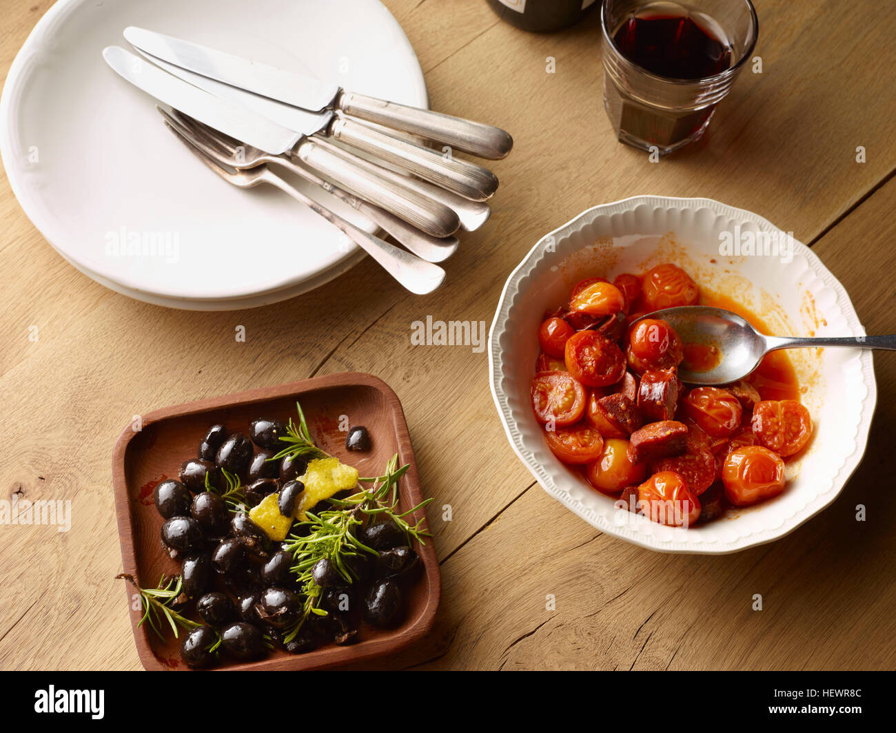 Overhead view of table with bowl of black olives and bowl of Spanish tomatoes with chorizo Stock