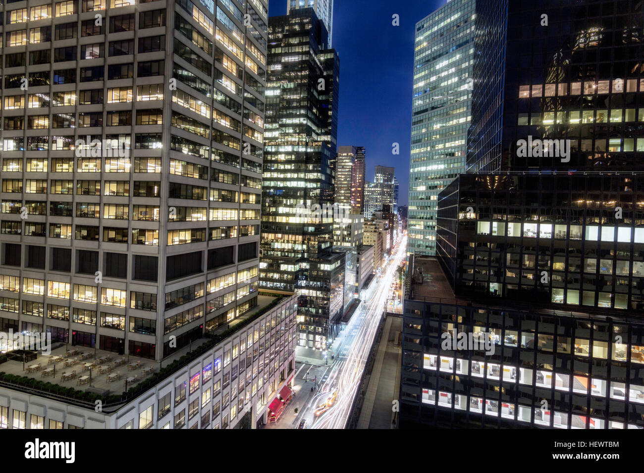 Elevated view of glass fronted skyscrapers illuminated at night, New York, USA Stock Photo