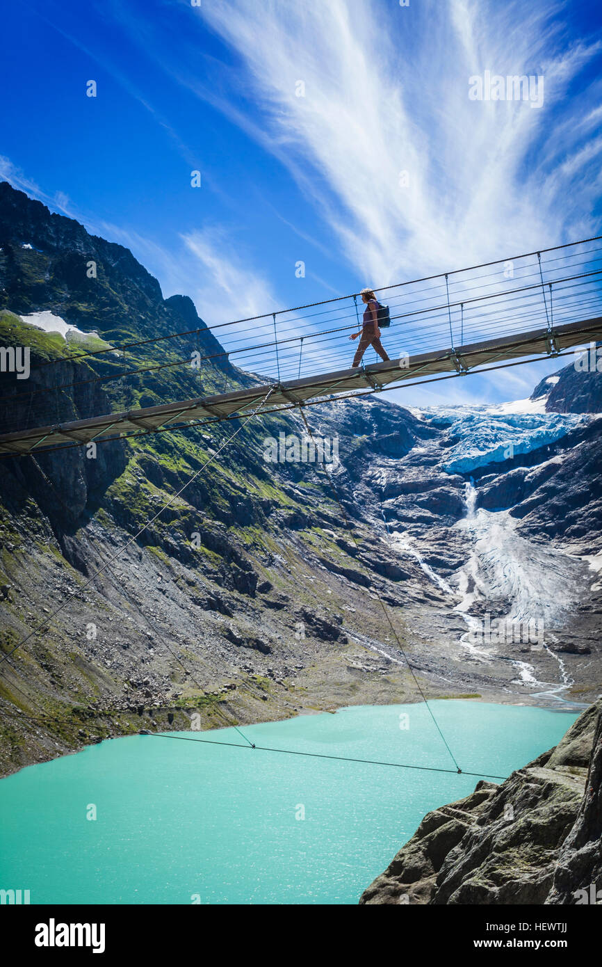 Tourist crossing Trift Bridge, Switzerland Stock Photo