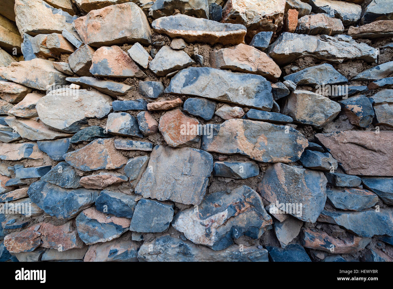 Stacked stones in an ancient handmade building wall in an abandoned desert village house. Stock Photo