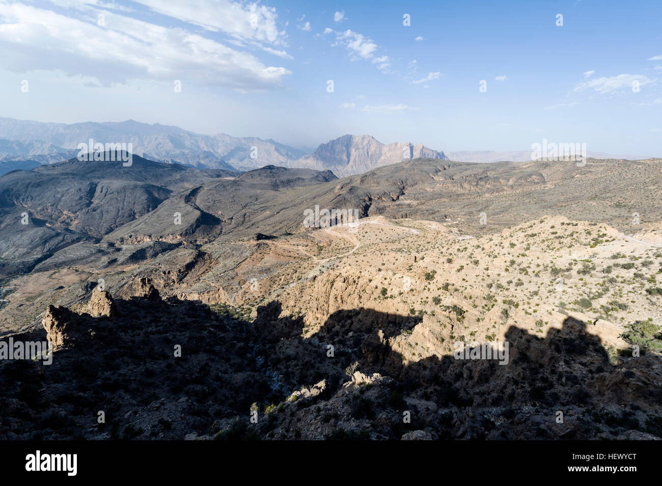 Arid jagged mountains overlook an eroded and inhospitable rocky desert valley. Stock Photo