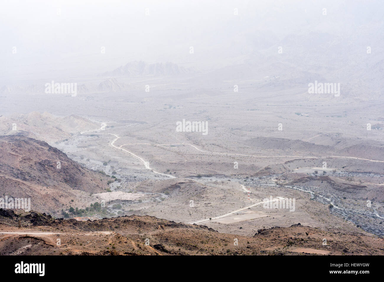 A dirt trail winds it's way through an arid desert valley. Stock Photo