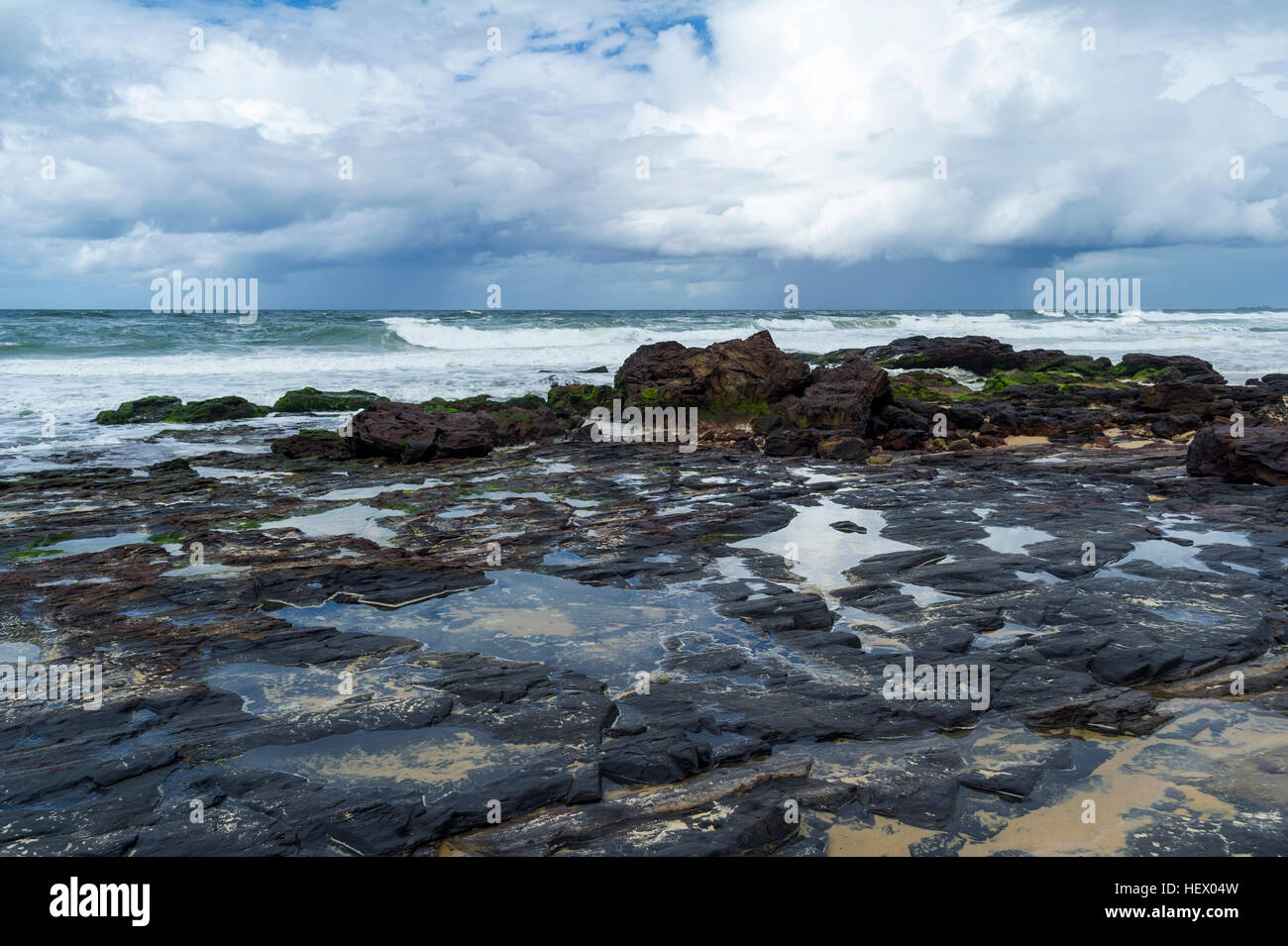 Exposed rock pools on the beach at low tide. Stock Photo