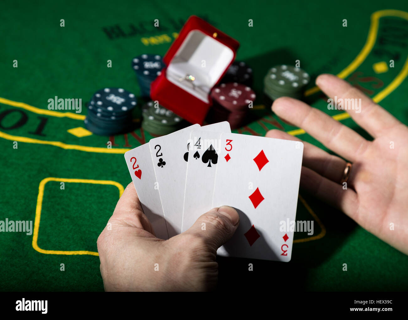 casino chips and a precious ring on green poker table background, man
