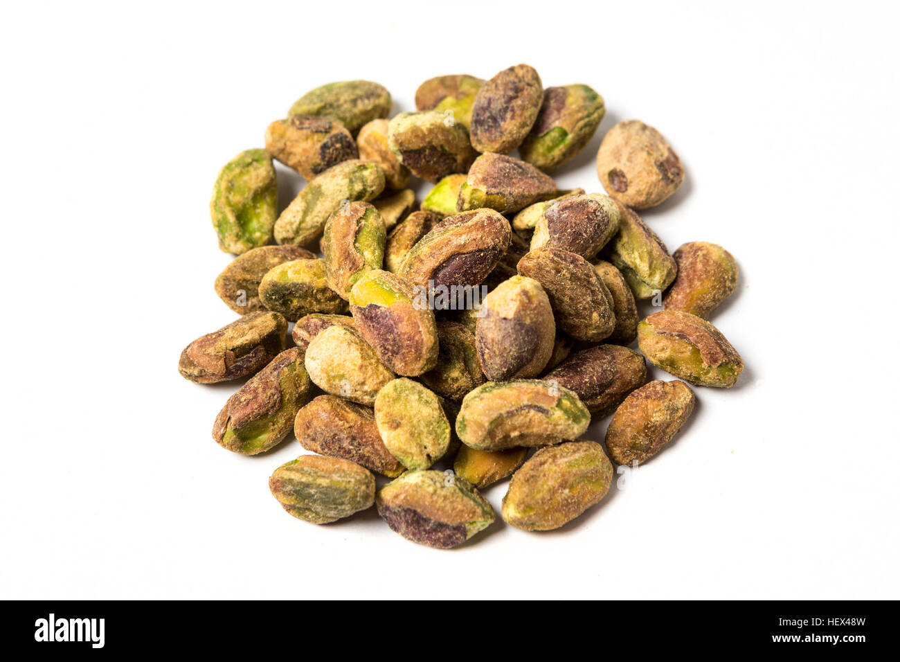 Unshelled pile of pistachios isolated on white background Stock Photo