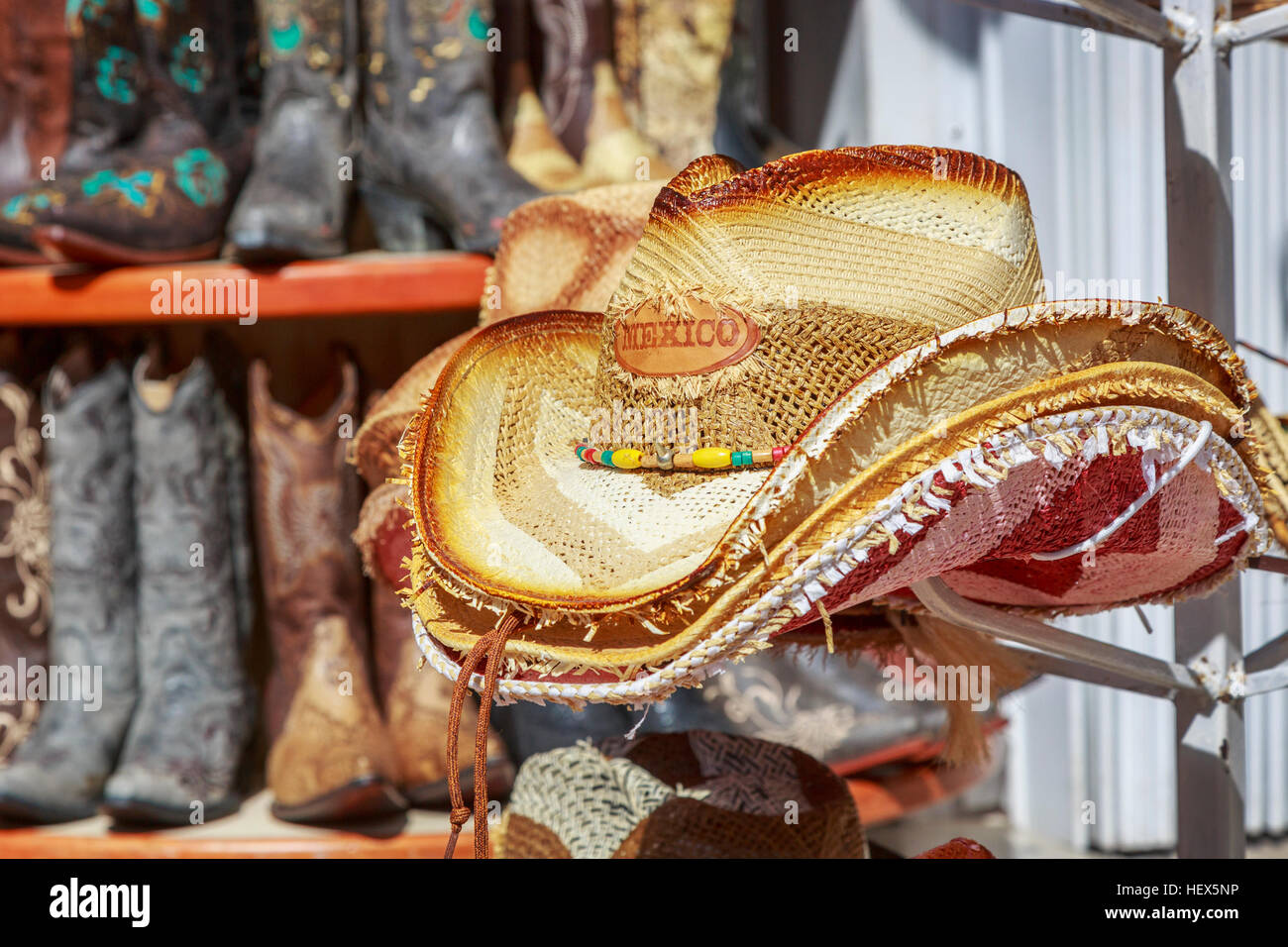 Straw hat embossed with Mexico and multicolored cowboy boots in the background, Playa Del Carmen, Mexico Stock Photo
