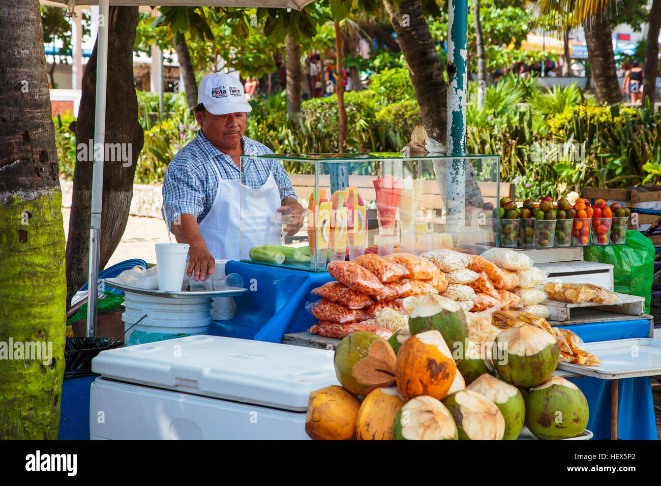 man selling fresh fruit and corn snacks from a stall on 5th Avenue, Playa Del Carmen, Riviera Maya, Mexico Stock Photo