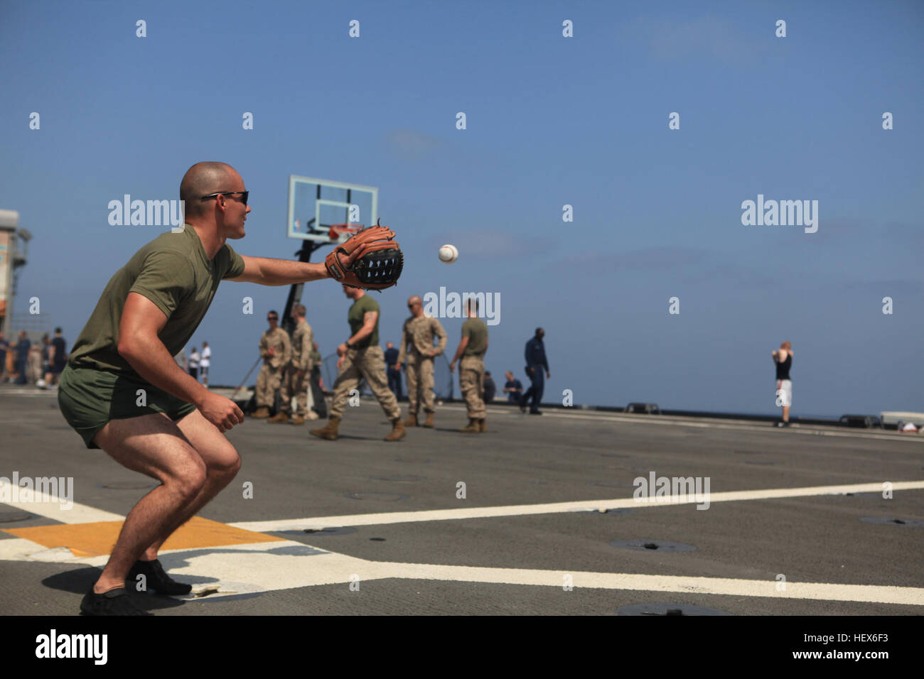 Sergeant Michael Castro, an infantryman with  Headquarters Platoon, Company K, Battalion Landing Team 3/8, 26th Marine Expeditionary Unit, catches a baseball on the flight deck of USS Ponce during a steel beach picnic, Oct. 16, 2010. The picnic was held to boost moral, increase camaraderie and offered fishing, swimming and other sports activities. 26th MEU is currently embarked aboard the ships of Kearsarge Amphibious Ready Group operating in the 5th Fleet area of responsibility. (Official USMC Photo by Staff Sgt. Danielle M. Bacon/ Released) USS Ponce Steel Beach DVIDS333281 Stock Photo
