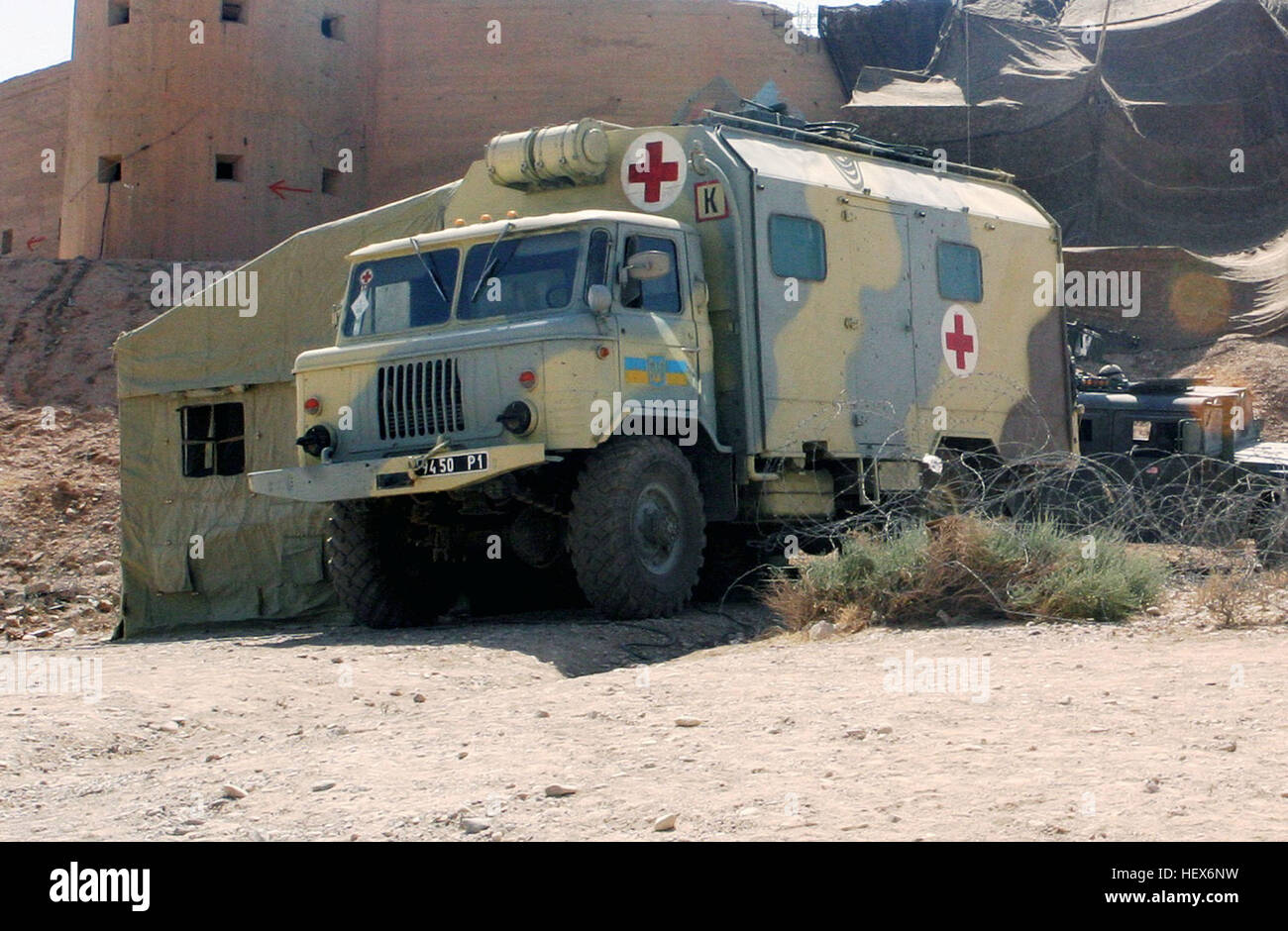 A Ukraine Army GAZ-66 (4X4) 2,000kg Ambulance Van sits with US Marine Corps (USMC) High-Mobility Multipurpose Wheeled Vehicles, assigned to India/Company, 3rd Battalion, 23rd Marine Regiment, outside a fortified structure near the Iran/Iraq border crossing located at Badrah, Iraq, during Operation IRAQI FREEDOM, as Ukraine Military Forces prepare to take command of the local area. Ukranian ambulance in Iraq Stock Photo