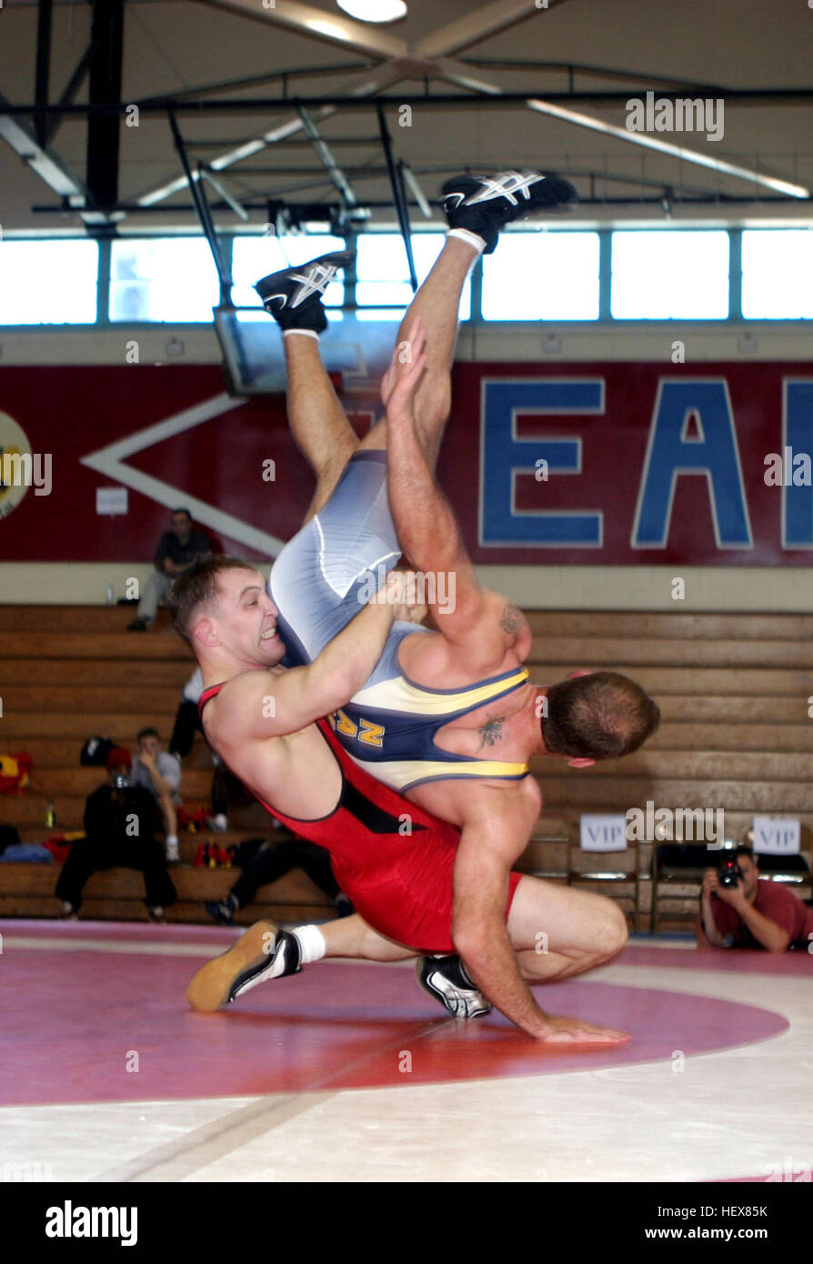 040306-M-7837W-003 New Orleans, La. (Mar. 6, 2004) Ð United States Marines Corps wrestler, Cpl. Jake Clark, in red, takes down United States Navy wrestler Joseph Axiotis to win the gold metal at the 2004 Armed Forces Wrestling Championship held at Archbishop Rummel High School, New Orleans, La. Cpl. Clark wrestles both Greco Roman and Freestyle in the 84K weight class, and is currently training with the U.S. Olympic Team in Colorado Springs, Colo.  Cpl. Clark is hoping to qualify for the 2004 Olympics in Athens, Greece. U.S. Marine Corps photo by Lance Cpl. Lydia L. Collison. (RELEASED) 040306 Stock Photo