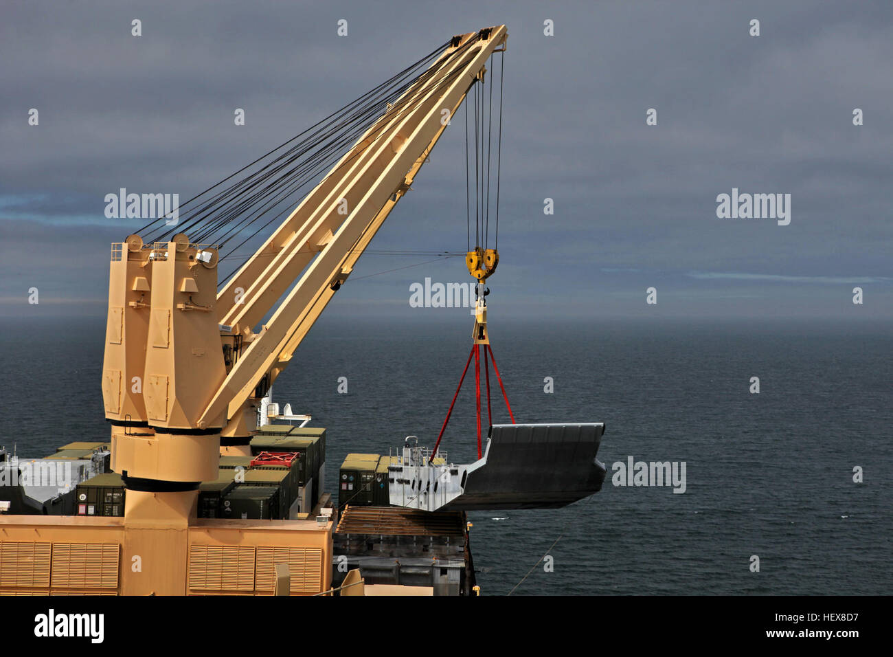 A crane offloads a beach landing module off the USNS Sgt. William ...