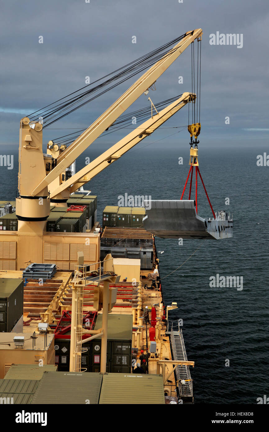 A crane offloads a beach landing module off the USNS Sgt. William ...