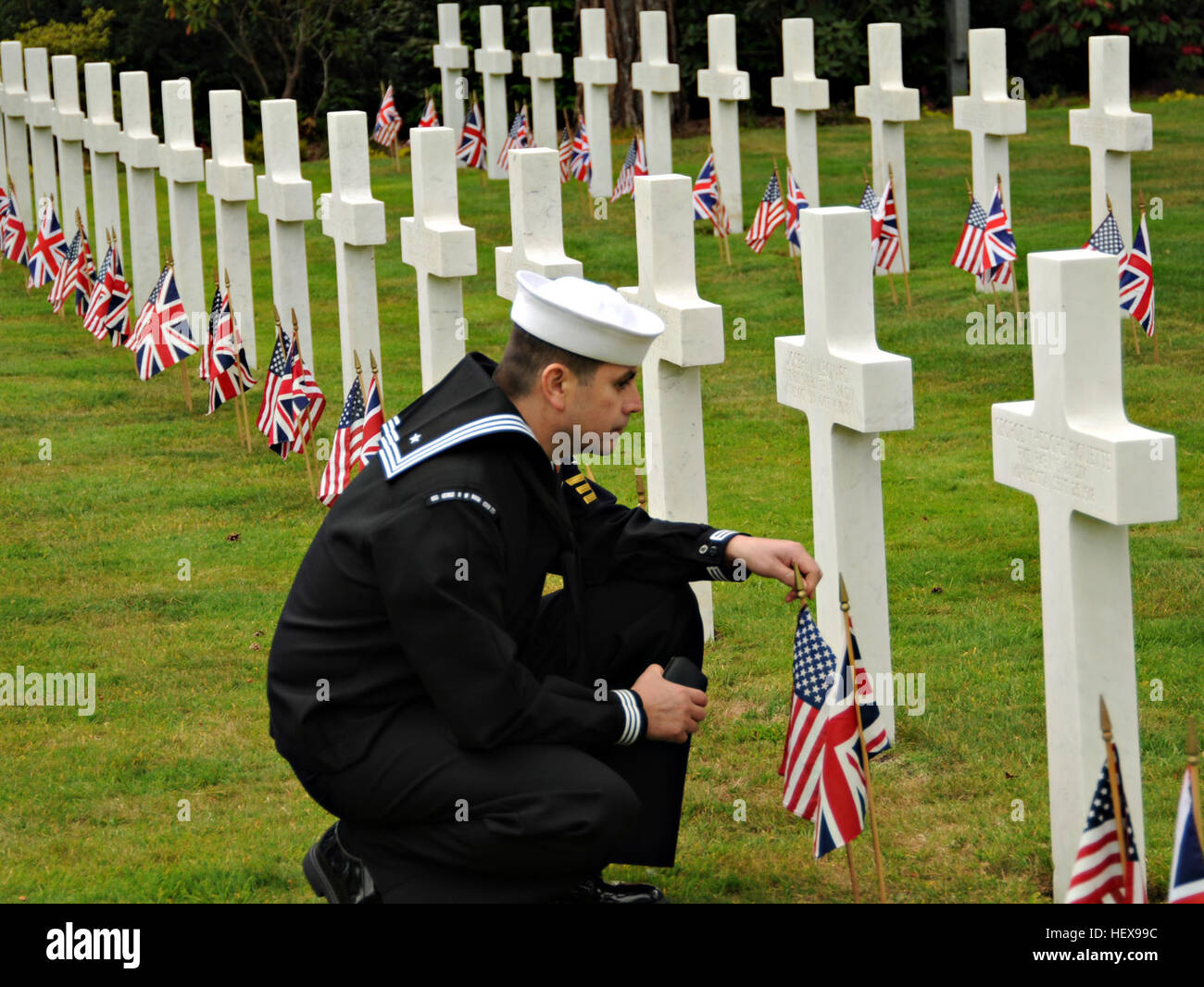 Petty Officer 1st Class Samuel Hernandez-Moreno, ship's serviceman, assigned to the aircraft carrier USS George H.W. Bush, pays his respects to a fallen service member buried at the Brookwood American Cemetery and Memorial on Memorial Day. George H.W. Bush is anchored off the coast of Portsmouth, England, for the ship's first overseas port visit of its first combat deployment. Flickr - DVIDSHUB - Memorial Day service at Brookwood American Cemetery and Memorial (Image 1 of 2) Stock Photo