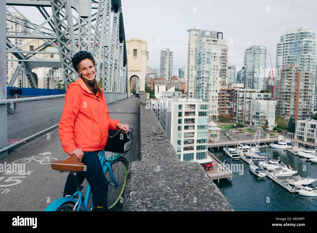 Portrait of young woman ready to ride bicycle on cycle path, Vancouver, British Columbia, Canada Stock Photo