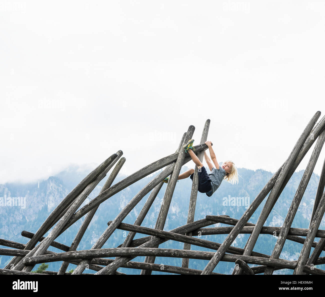 Boy climbing wooden structure in playground, Fuessen, Bavaria, Germany Stock Photo