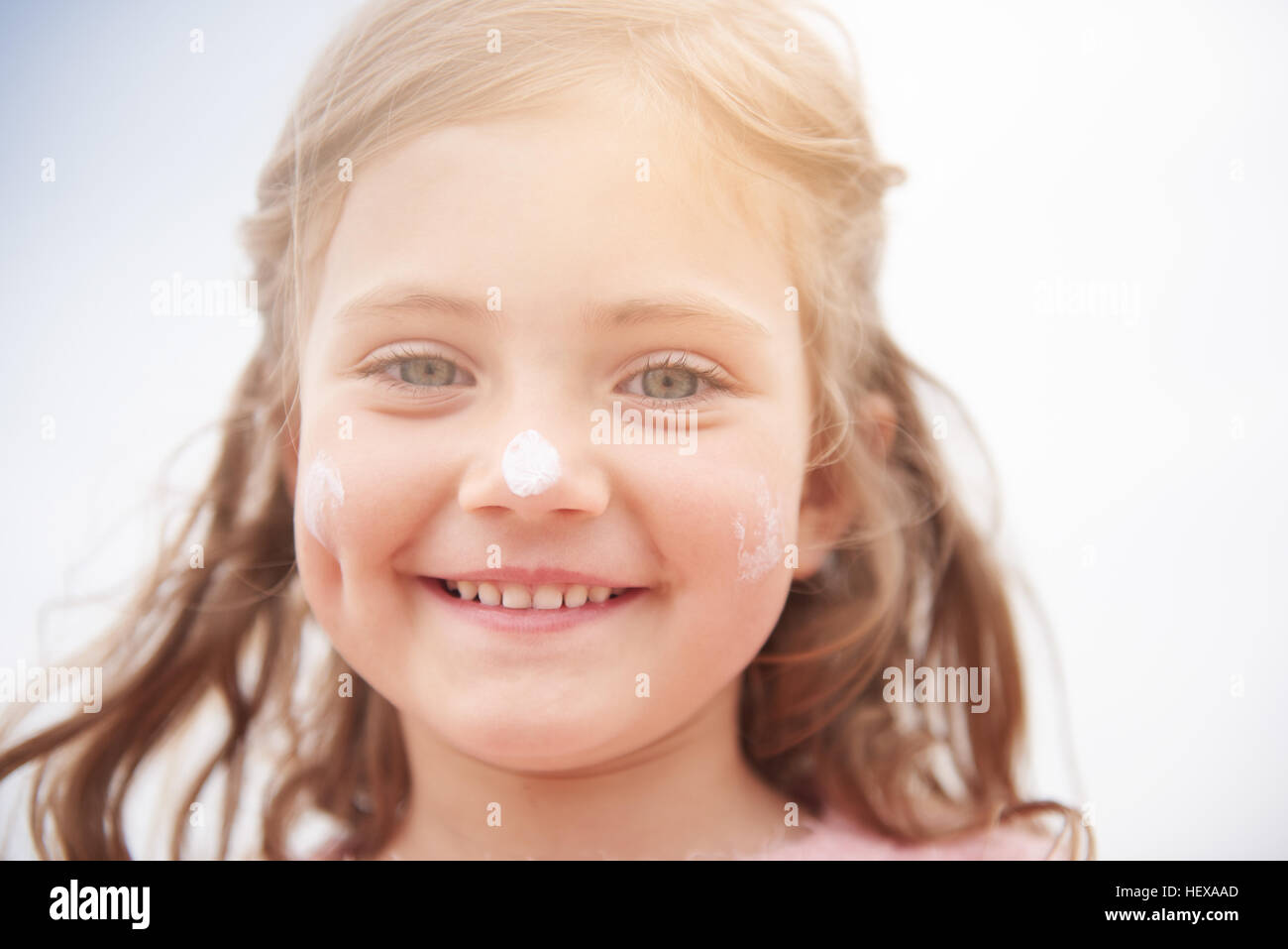 Little girl with sun cream on nose Stock Photo