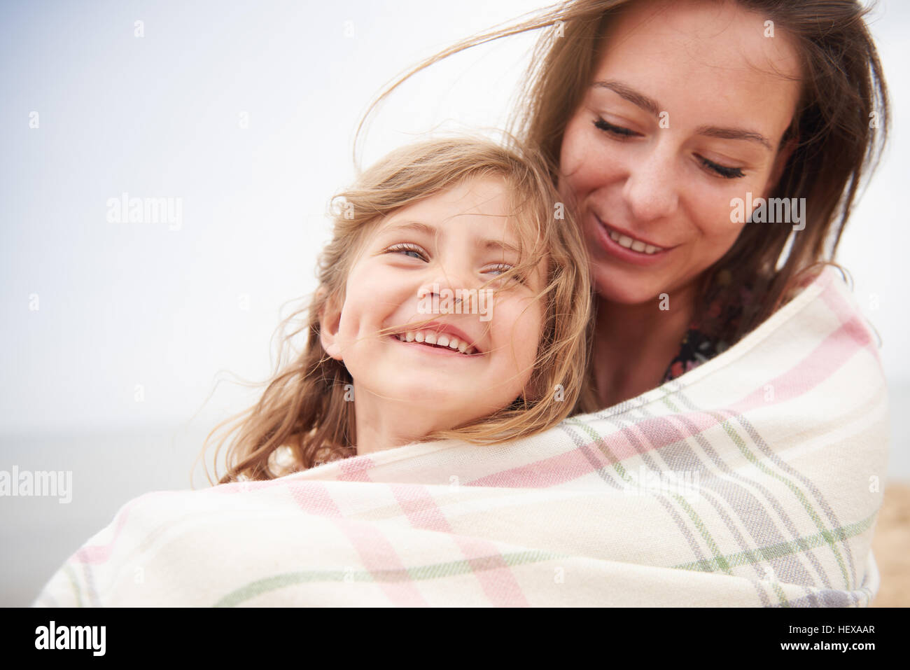 Happy mother and daughter wrapped in blanket Stock Photo Alamy