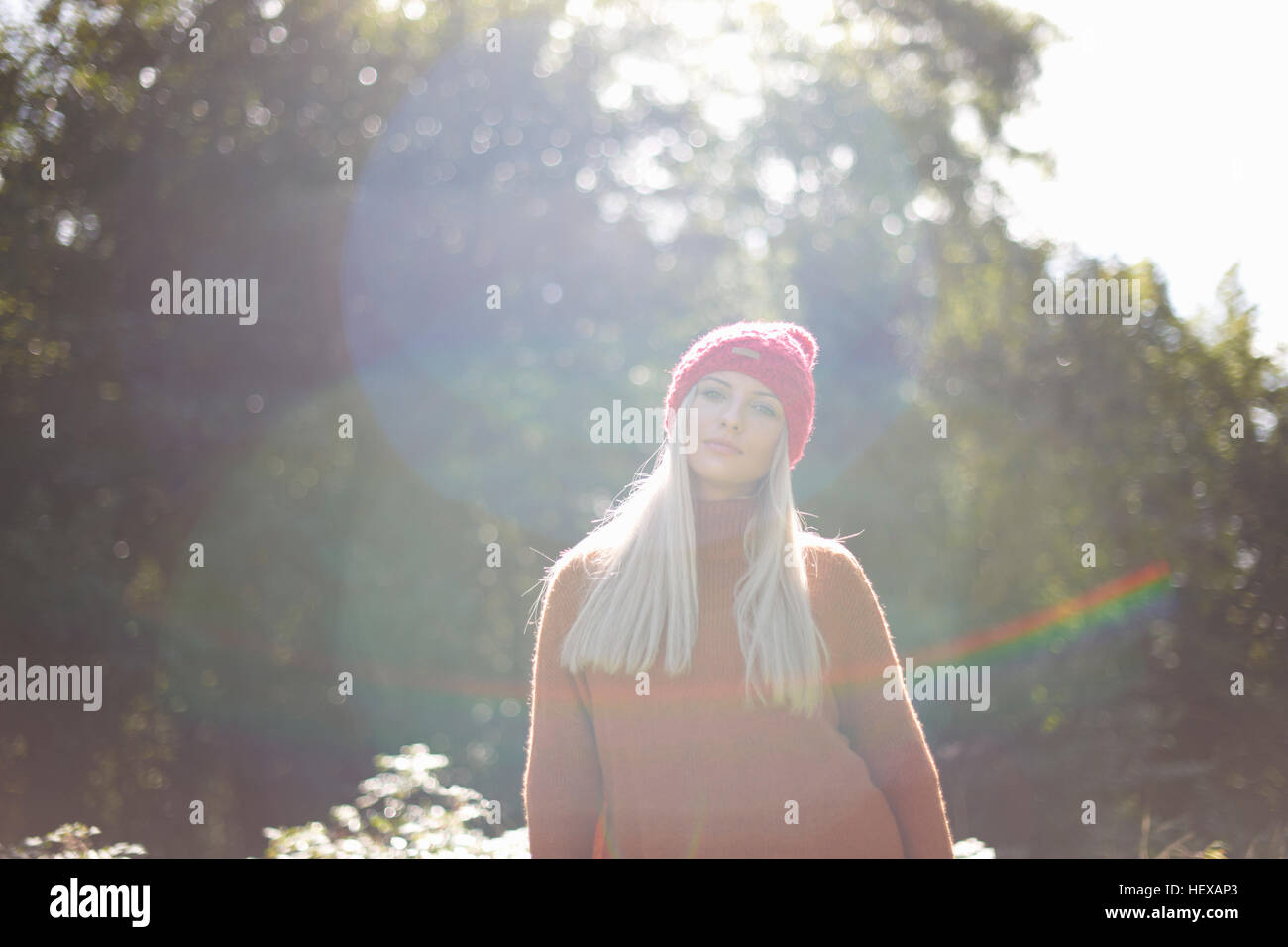 Portrait of woman in forest wearing knit hat looking at camera Stock Photo