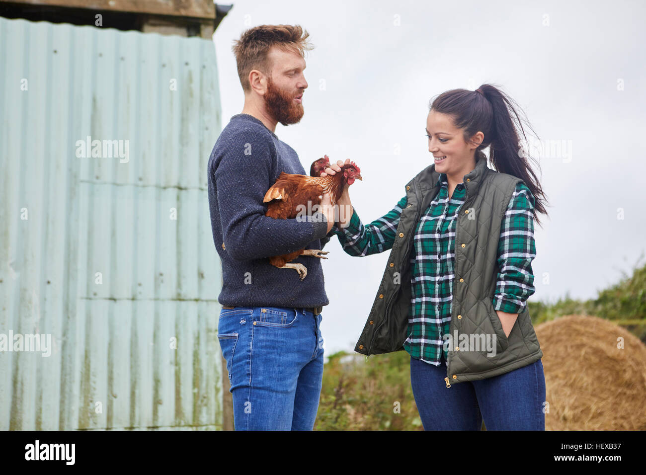 Young couple on chicken farm holding chickens Stock Photo