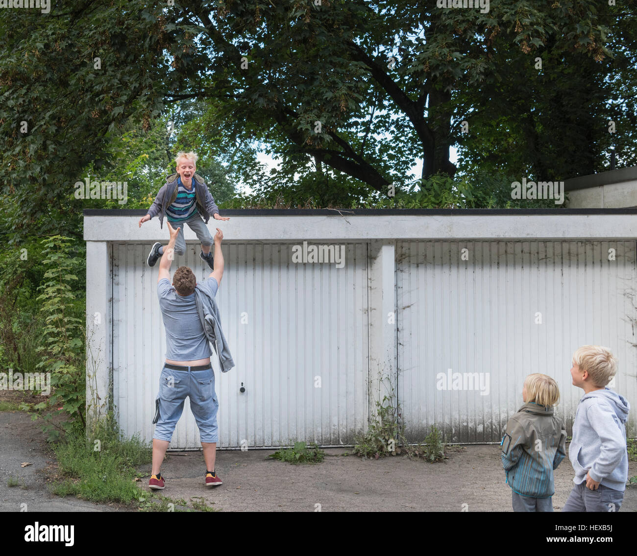 Boy jumping from garage into father's open arms Stock Photo