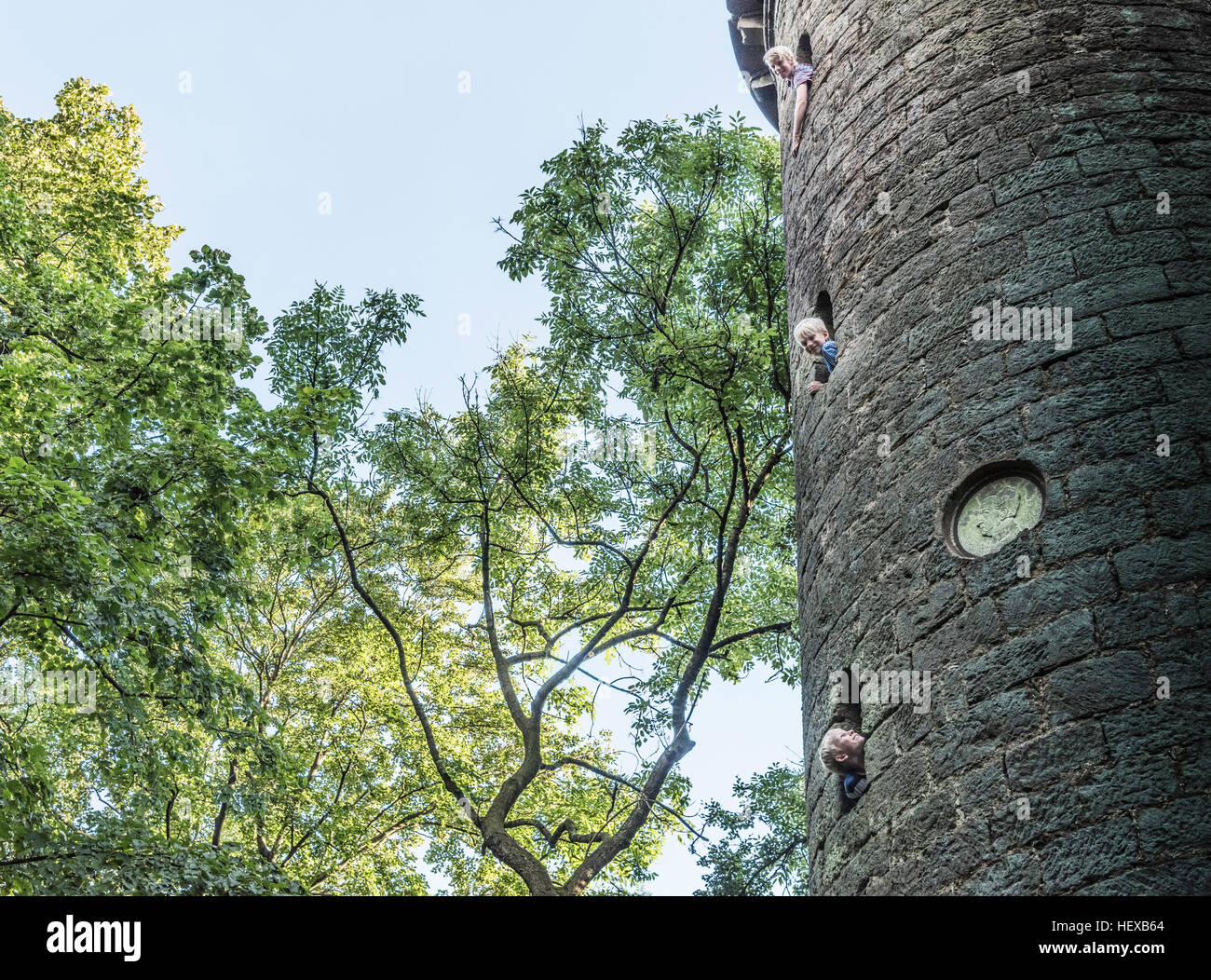 Boys leaning out of stone tower windows Stock Photo