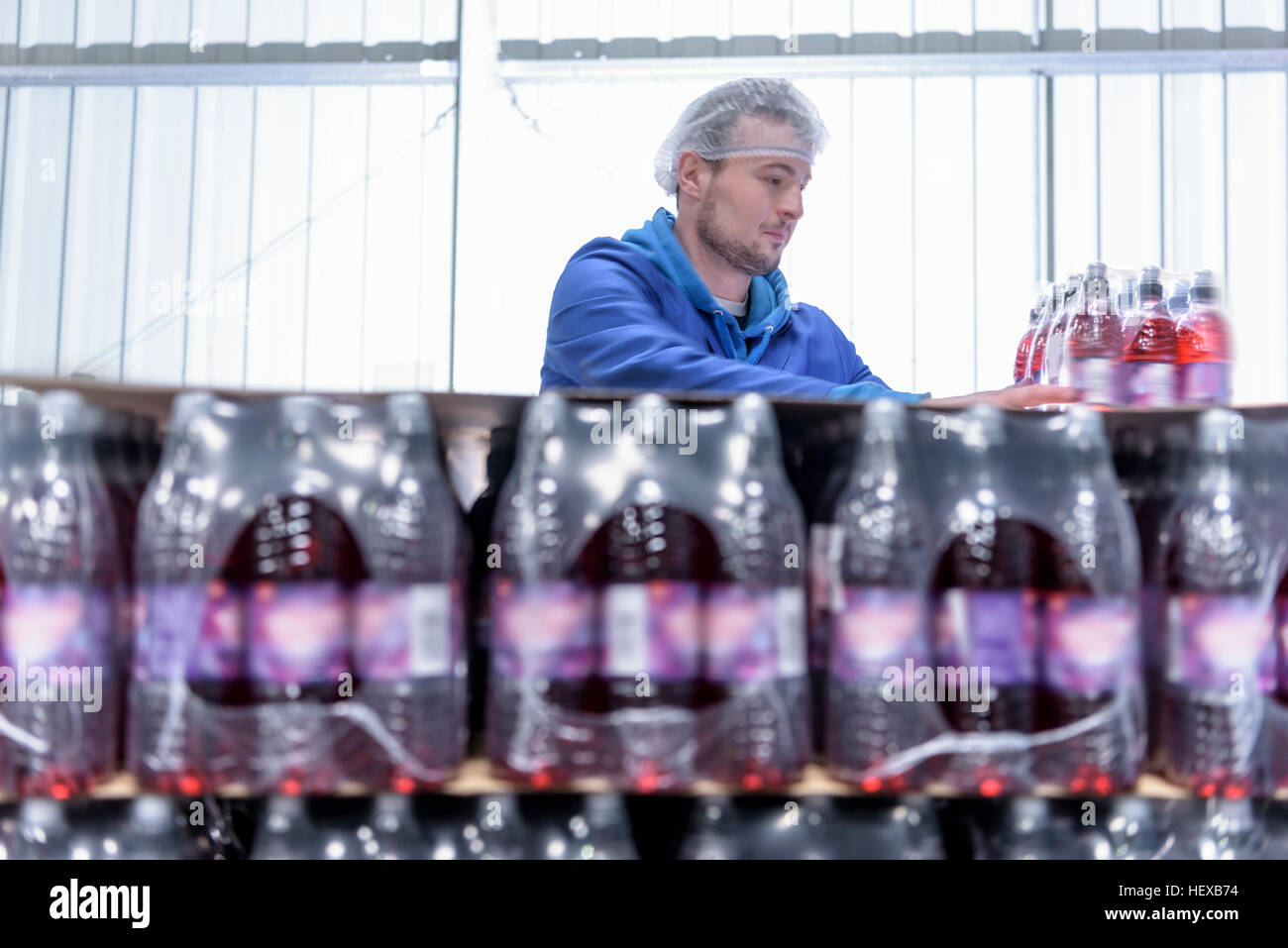 Worker packing flavoured water bottles in spring water factory Stock Photo