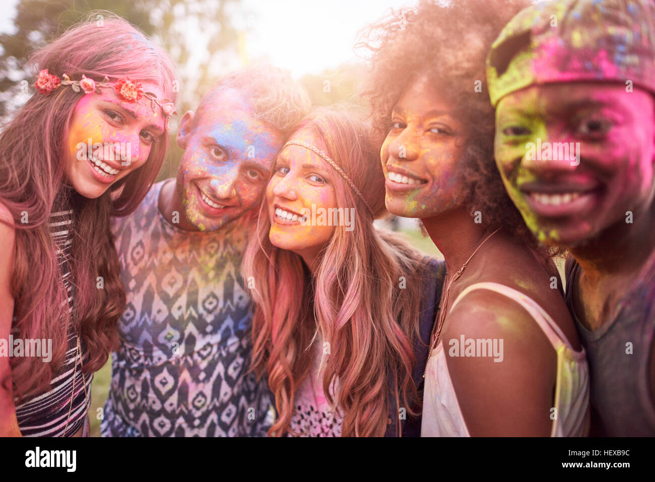 Portrait of group of friends at festival, covered in colourful powder paint Stock Photo