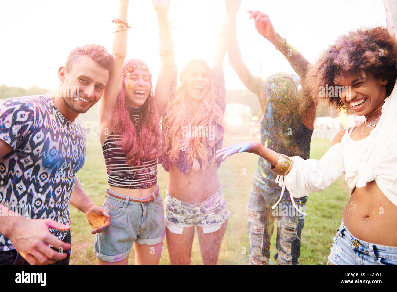 Group of friends at festival, covered in colourful powder paint Stock Photo