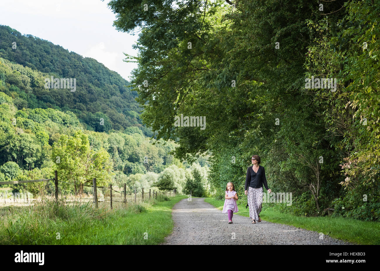 Mother and daughter walking on rural road, Porta Westfalica, North Rhine Westphalia, Germany Stock Photo