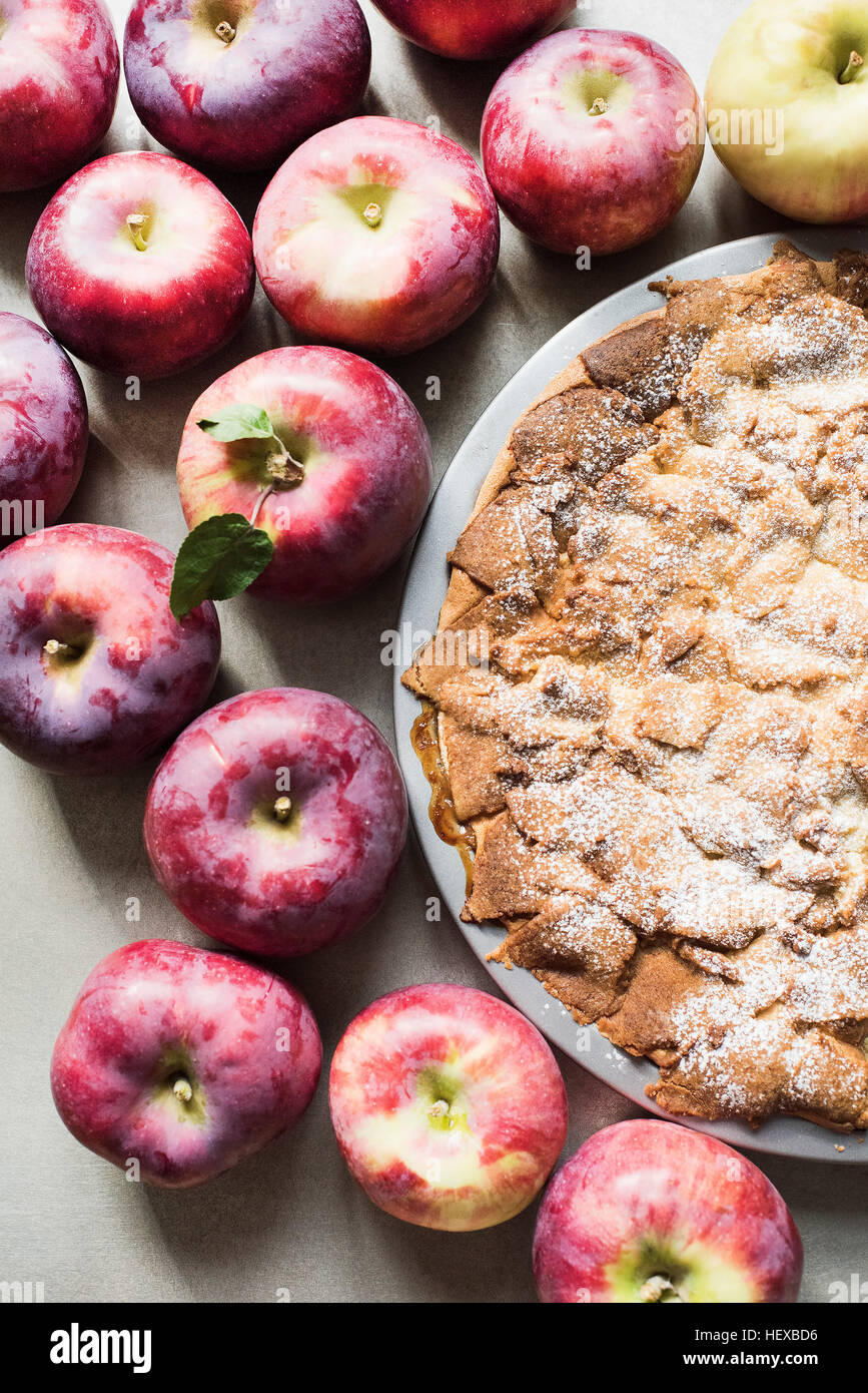 Apple pie with fresh Empire apples, overhead view Stock Photo