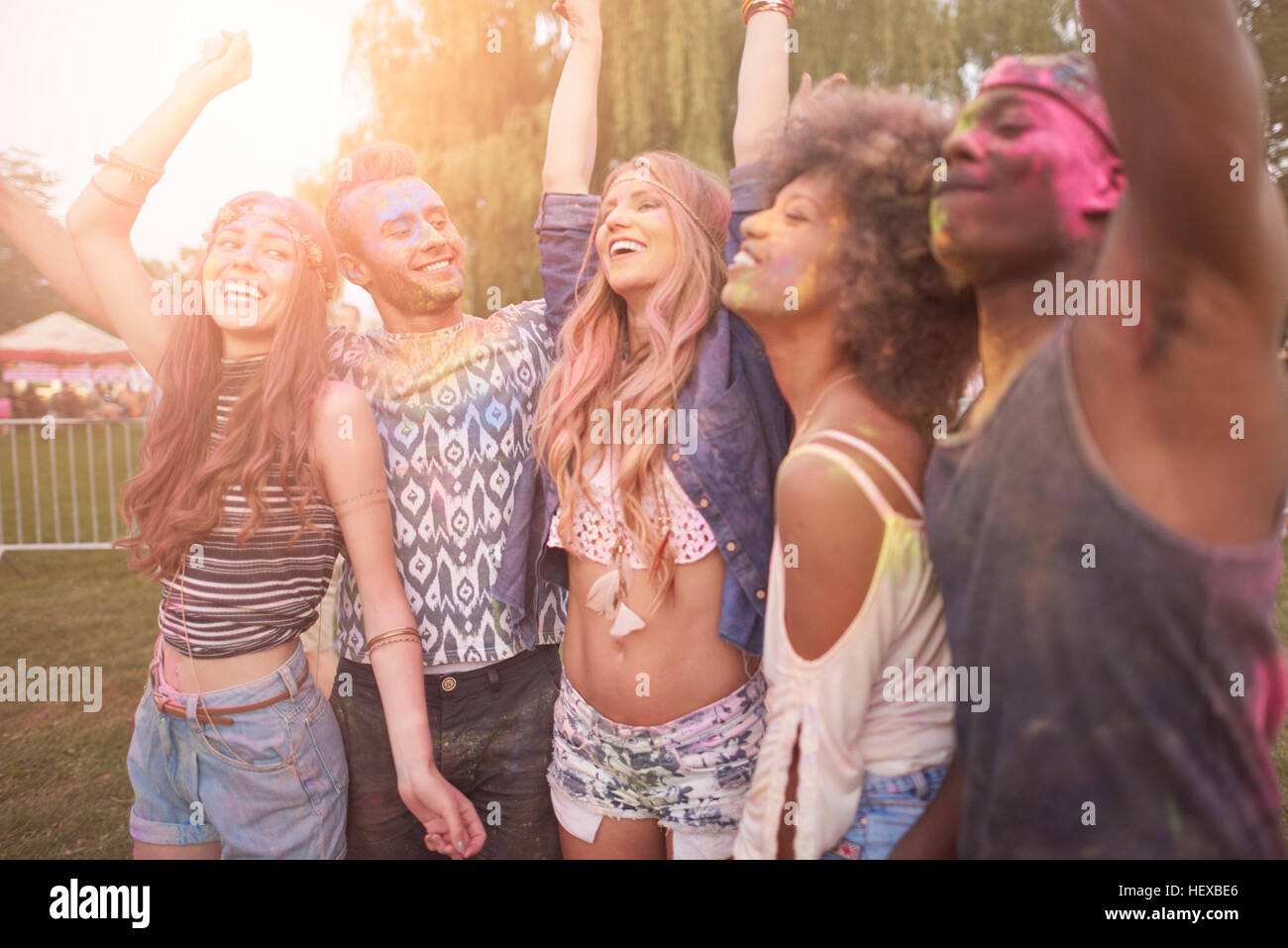 Group of friends at festival, covered in colourful powder paint Stock Photo