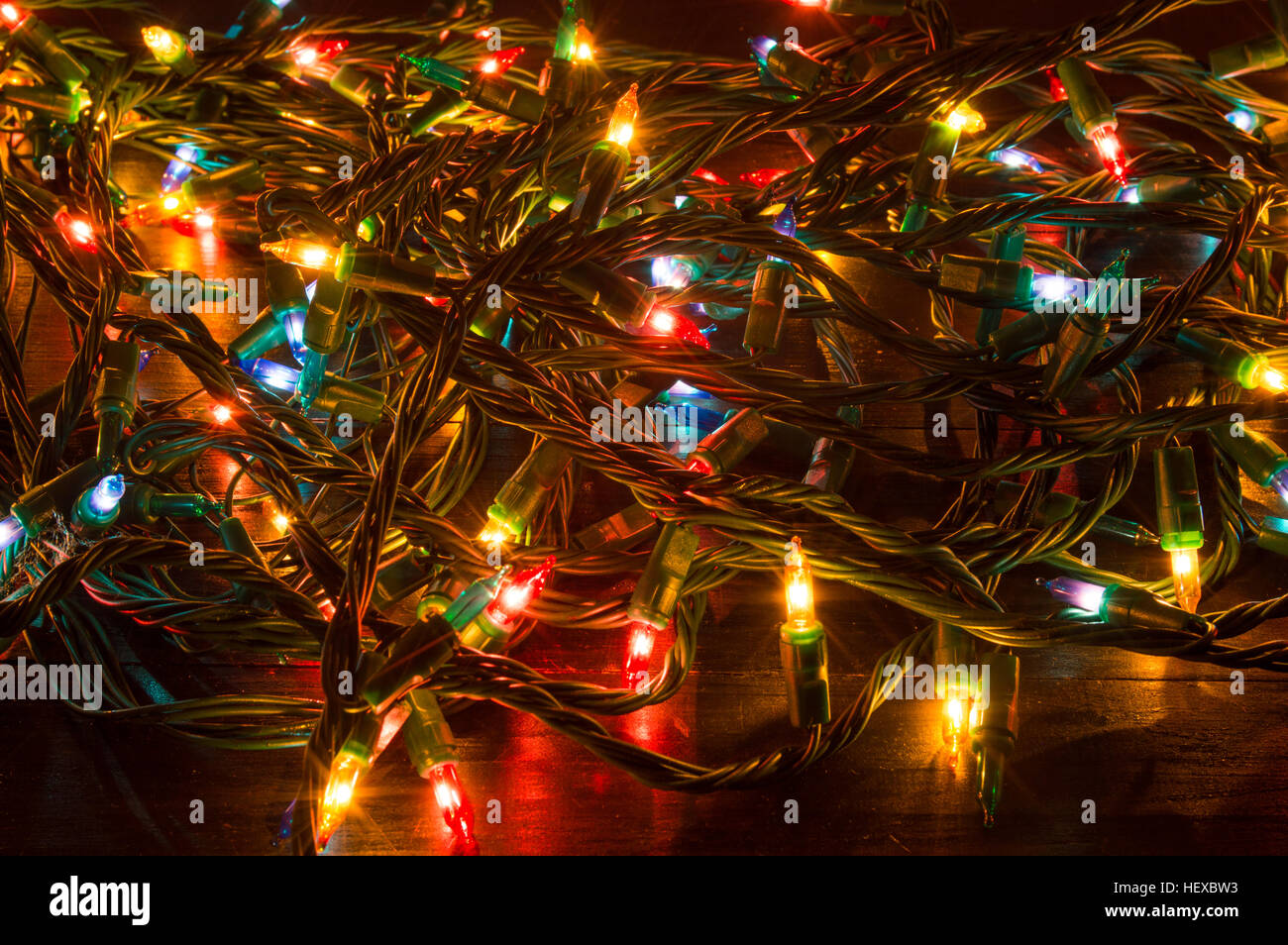 Tangled Christmas lights shining on a table Stock Photo Alamy