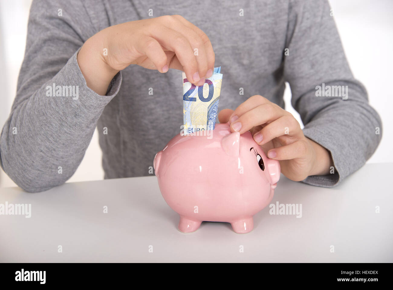 MODEL RELEASED. Boy putting money in piggy bank, smiling Stock Photo ...