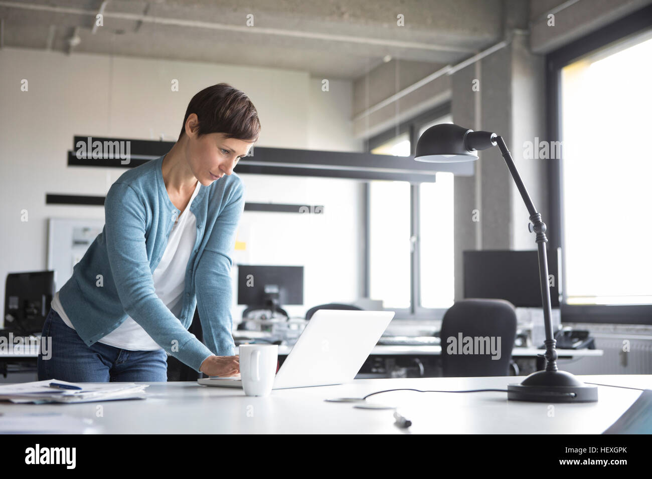 Businesswoman in office using laptop Stock Photo