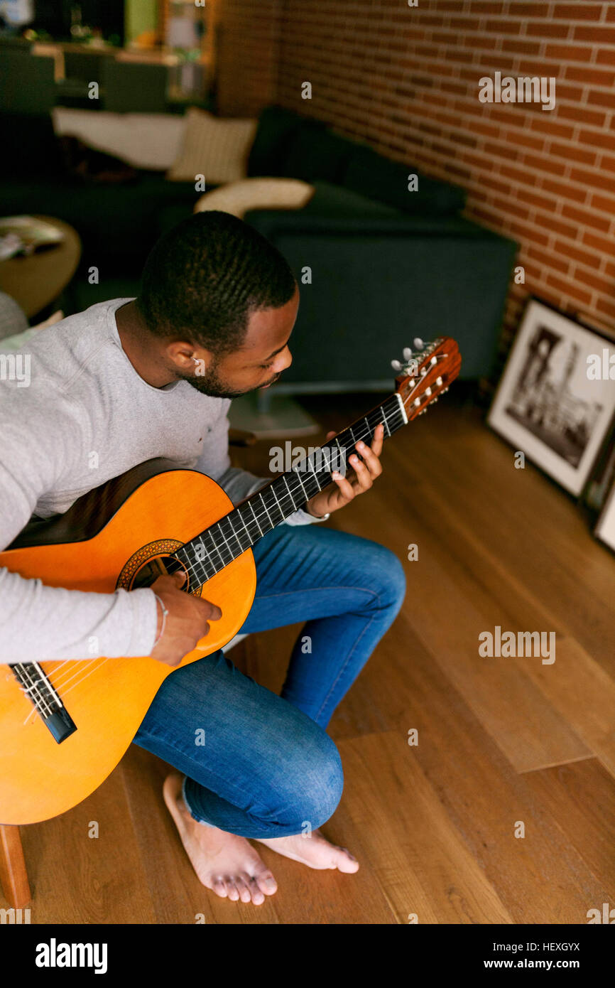 Young man at home playing guitar Stock Photo - Alamy